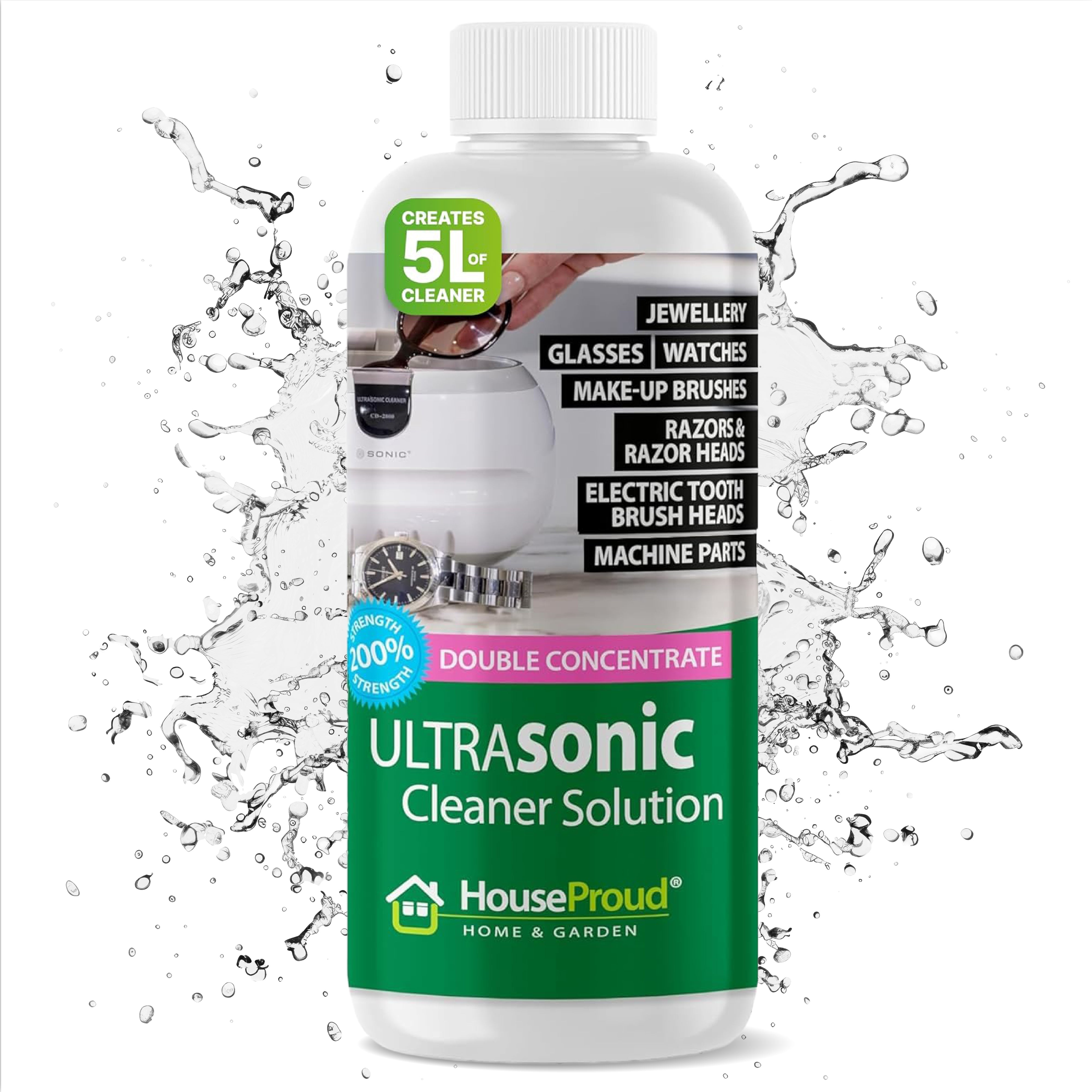 HouseProud Ultrasonic Cleaner Fluid concentrate bottle next to an ultrasonic cleaning bath with sparkling gold and silver jewellery
